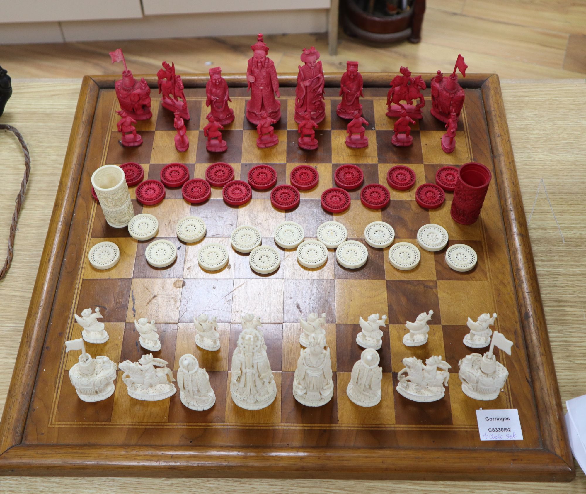 A 19th century Cantonese ivory chess and draught set, with later wood chess board and display cabinet